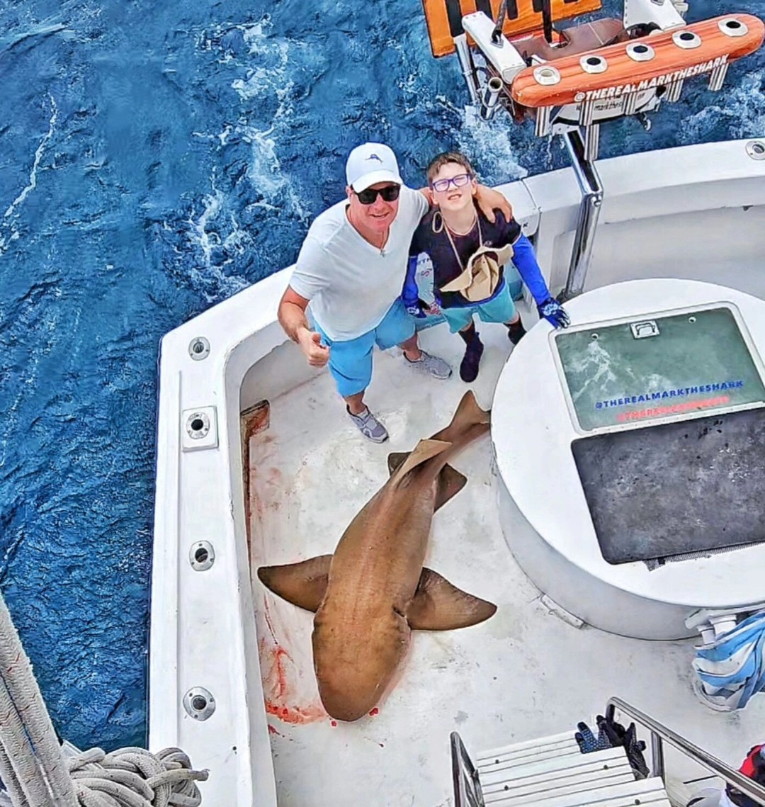Shark caught on fishing boat in Pompano Beach FL with two anglers posing