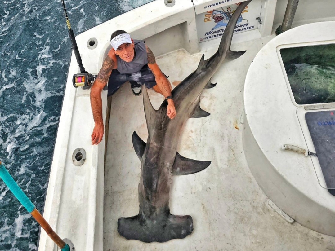 South Florida offshore fishing charter boat with captain and guests fishing in ocean waters