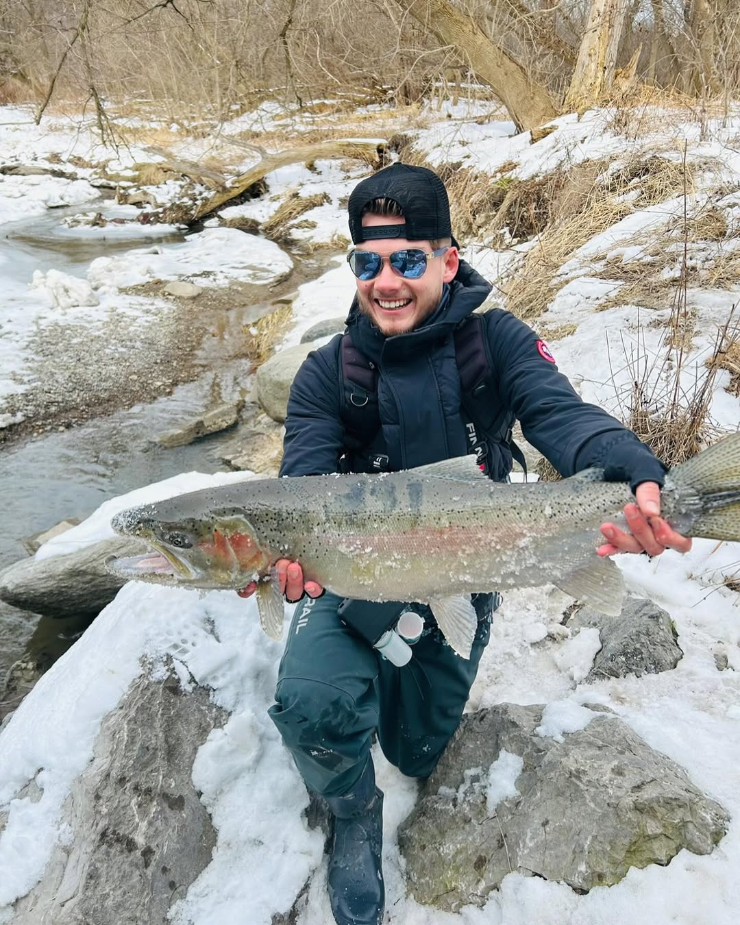 Proud angler holding a beautiful rainbow trout caught at Niagara Falls