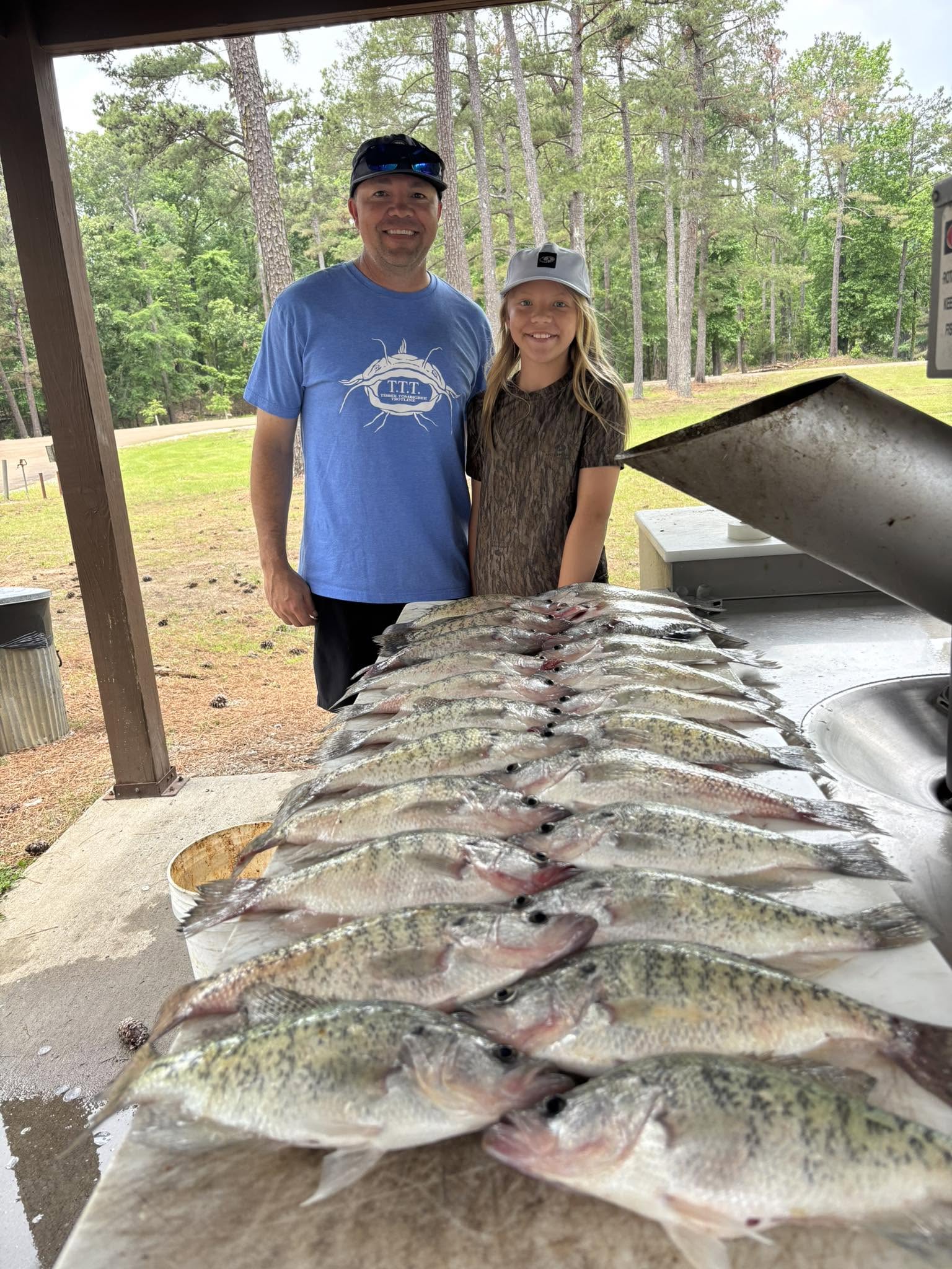 Large catch of bass laid out on cleaning table at fish cleaning station in Batesville MS