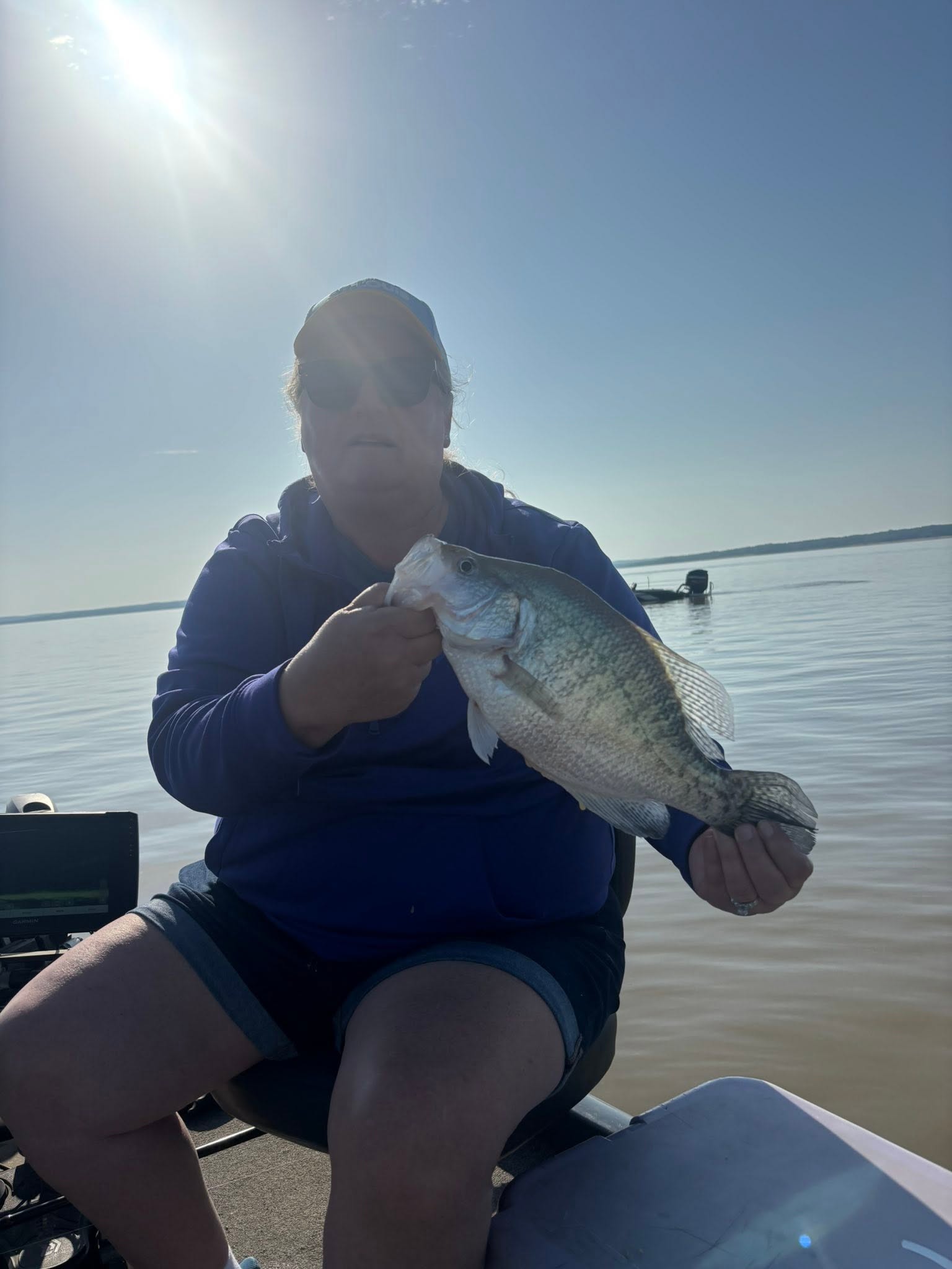 Angler holding freshly caught fish on boat in Batesville MS waters