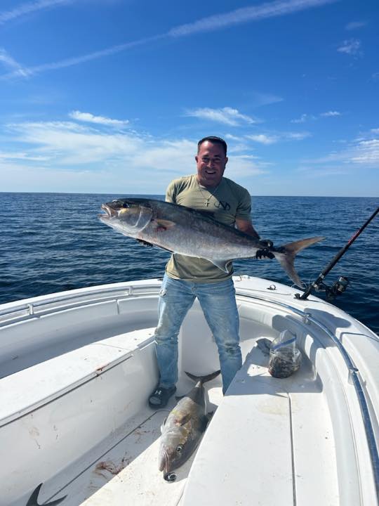 Angler holding large fish catch on fishing boat in St. Augustine FL waters