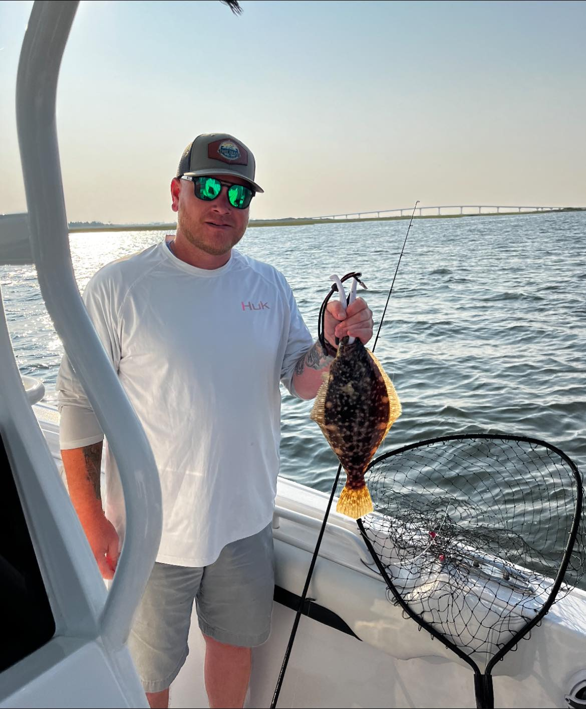 Fisherman holding a summer flounder in the ocean at Ocean City