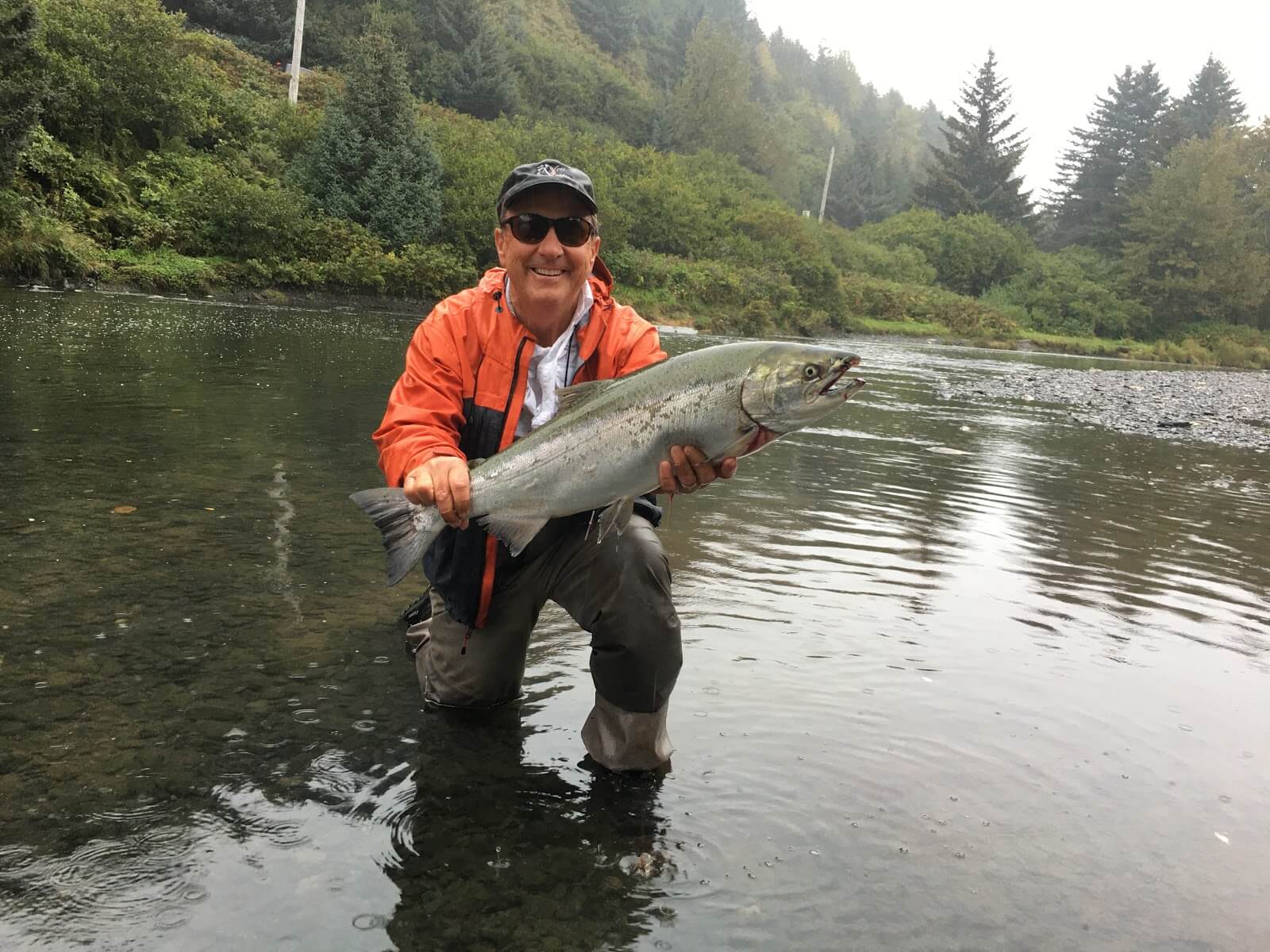 A single fisherman stands in Kodiak, fishing gear in hand.