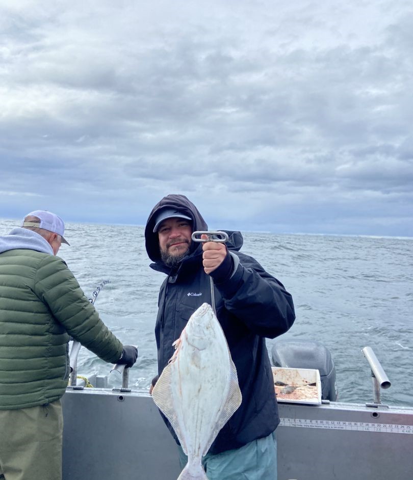 Angler holding a large Pacific Halibut in Alaska