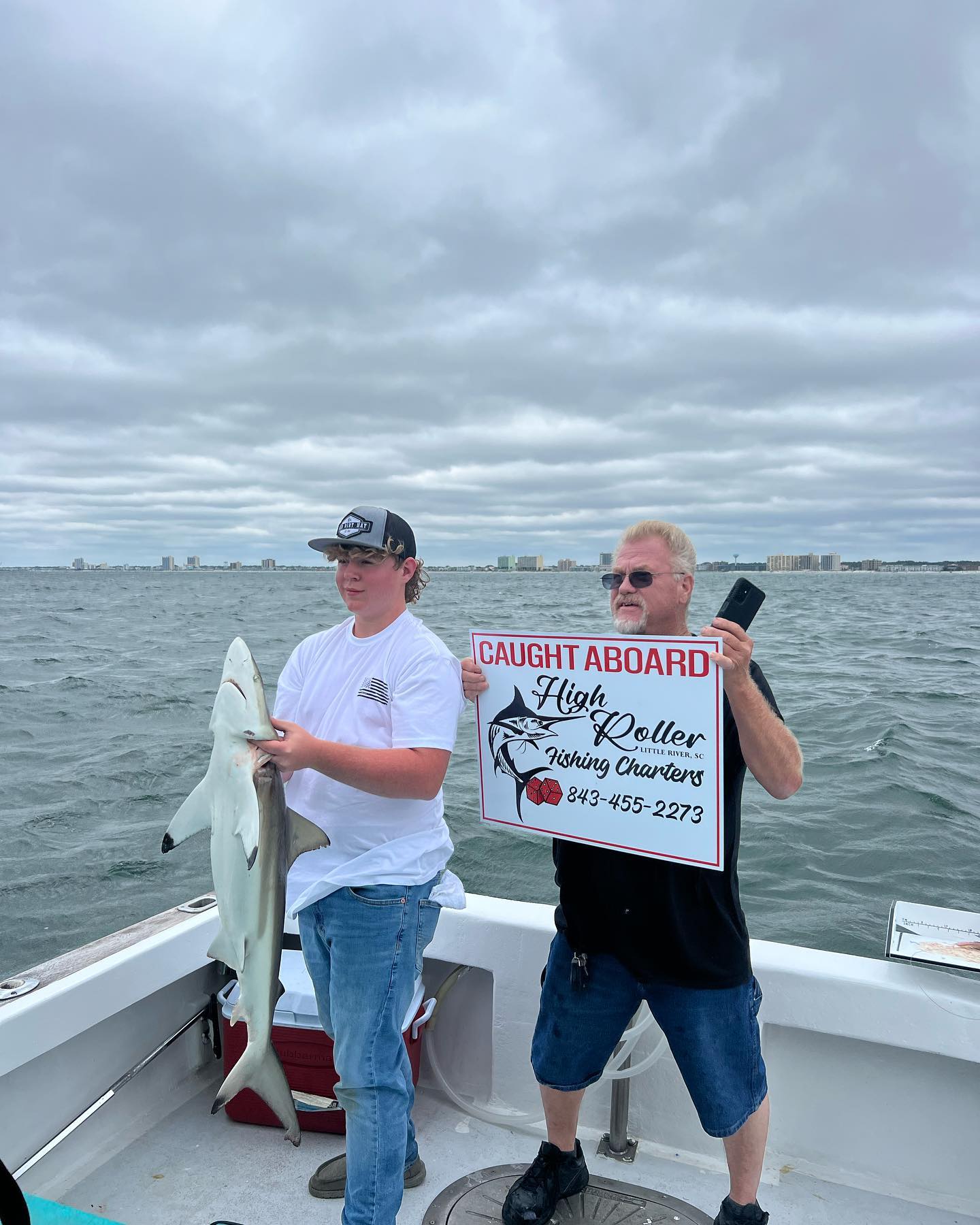 Angler holding a large Atlantic Sharpnose Shark in Little River