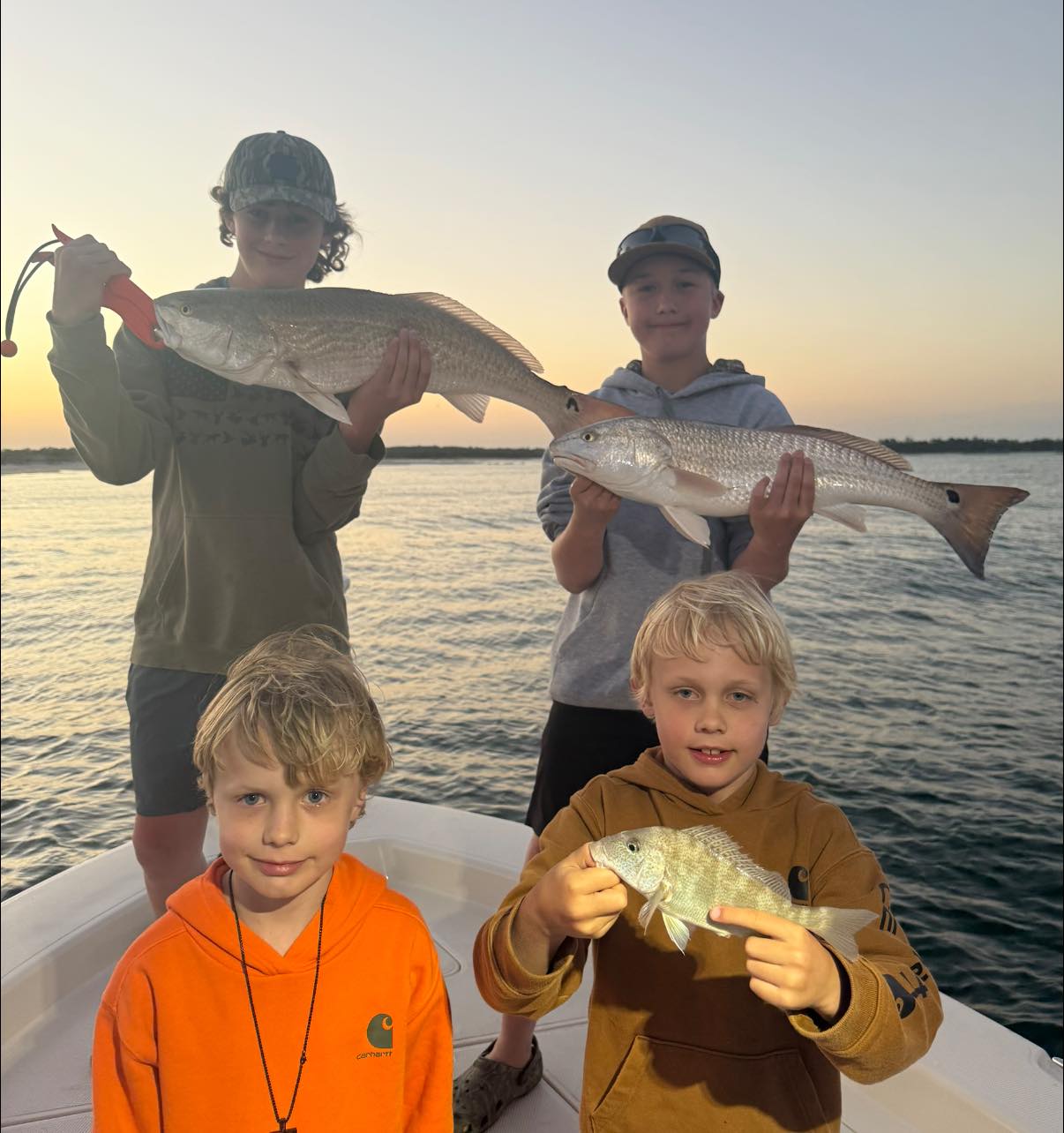 Successful redfish fishing trip in Pensacola FL showing multiple caught redfish on boat at sunset