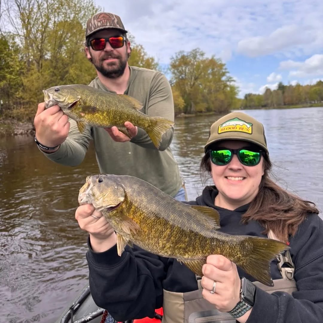 Two anglers display caught smallmouth bass on lake in Stanwood MI