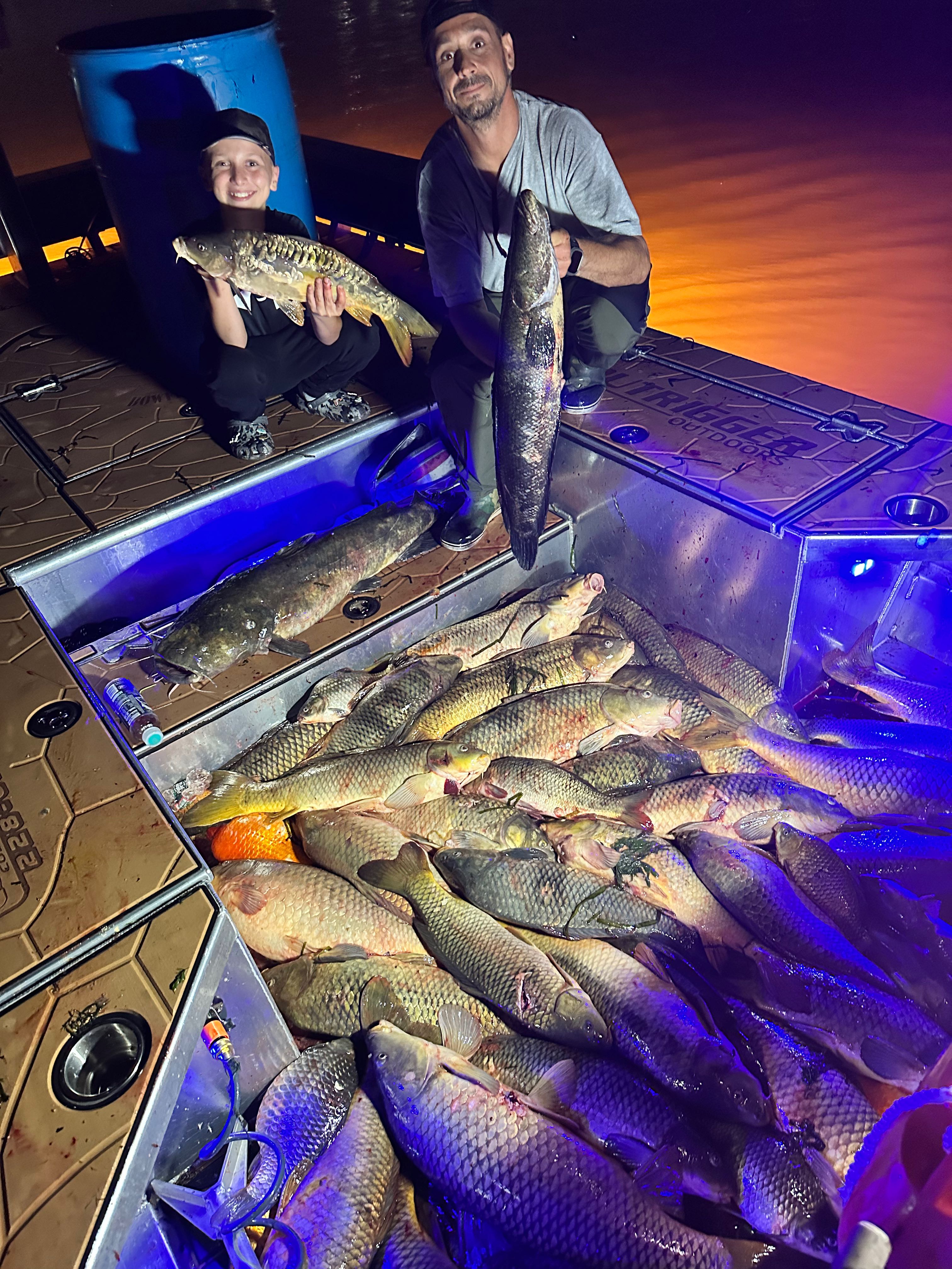 Bowfishing archer targeting carp at night on river with Captain Dom guided fishing trip