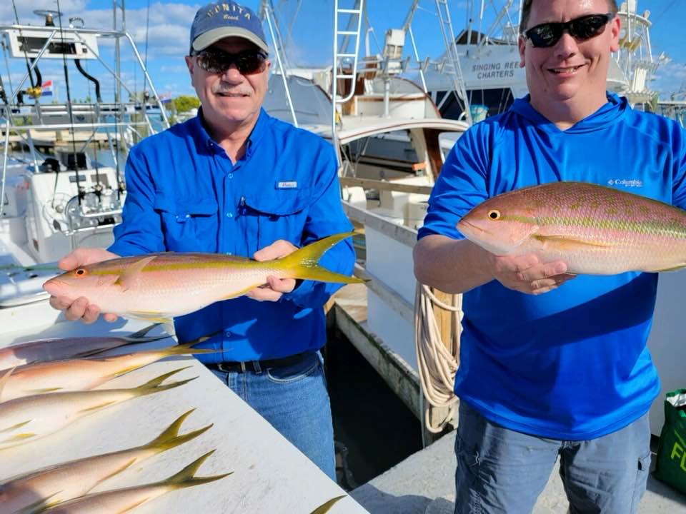 Two anglers holding large, unidentified fish in Islamorada