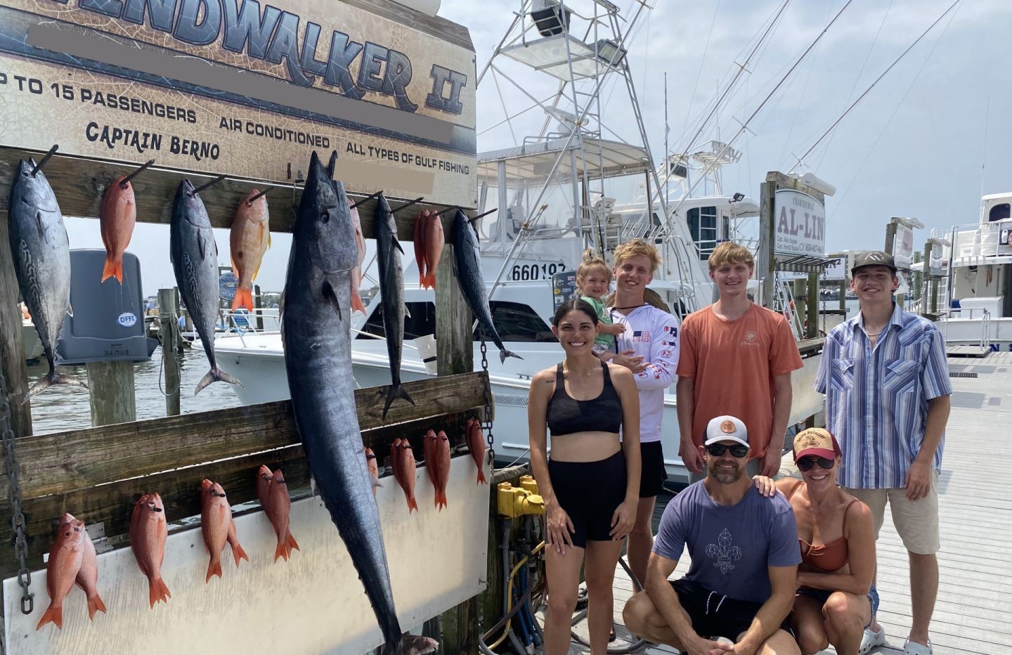 Fishing charter catch display in Destin FL showing wahoo, little tunny, and king mackerel hanging on dock