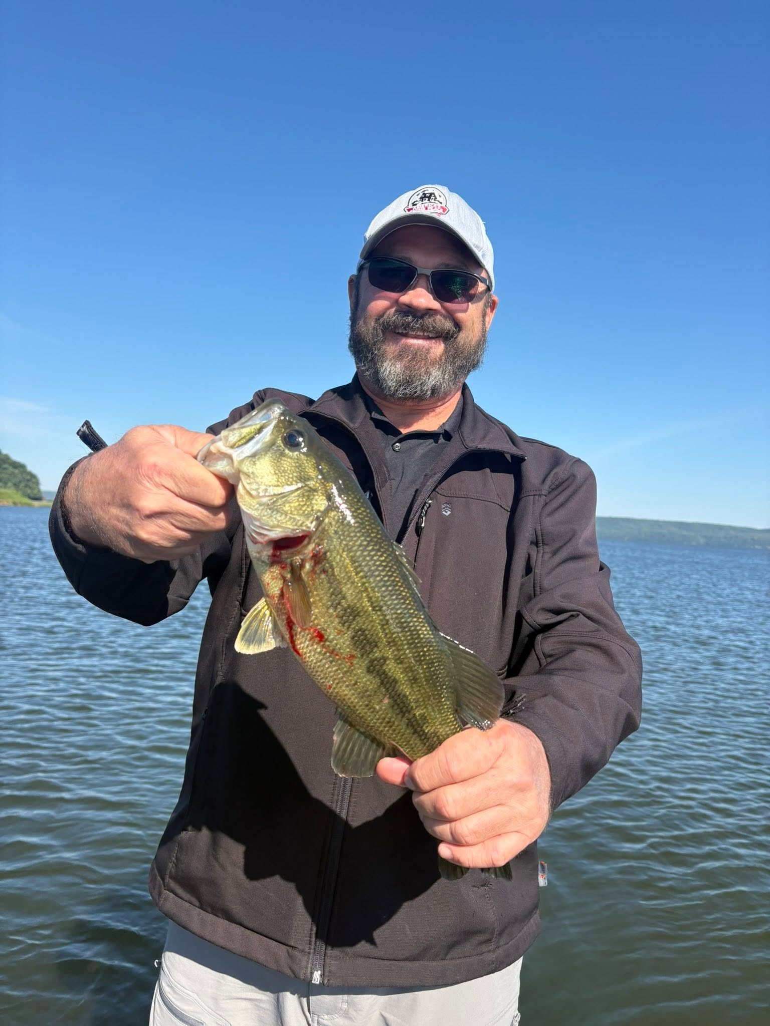 Angler holding freshly caught bass on lake in Guntersville Alabama