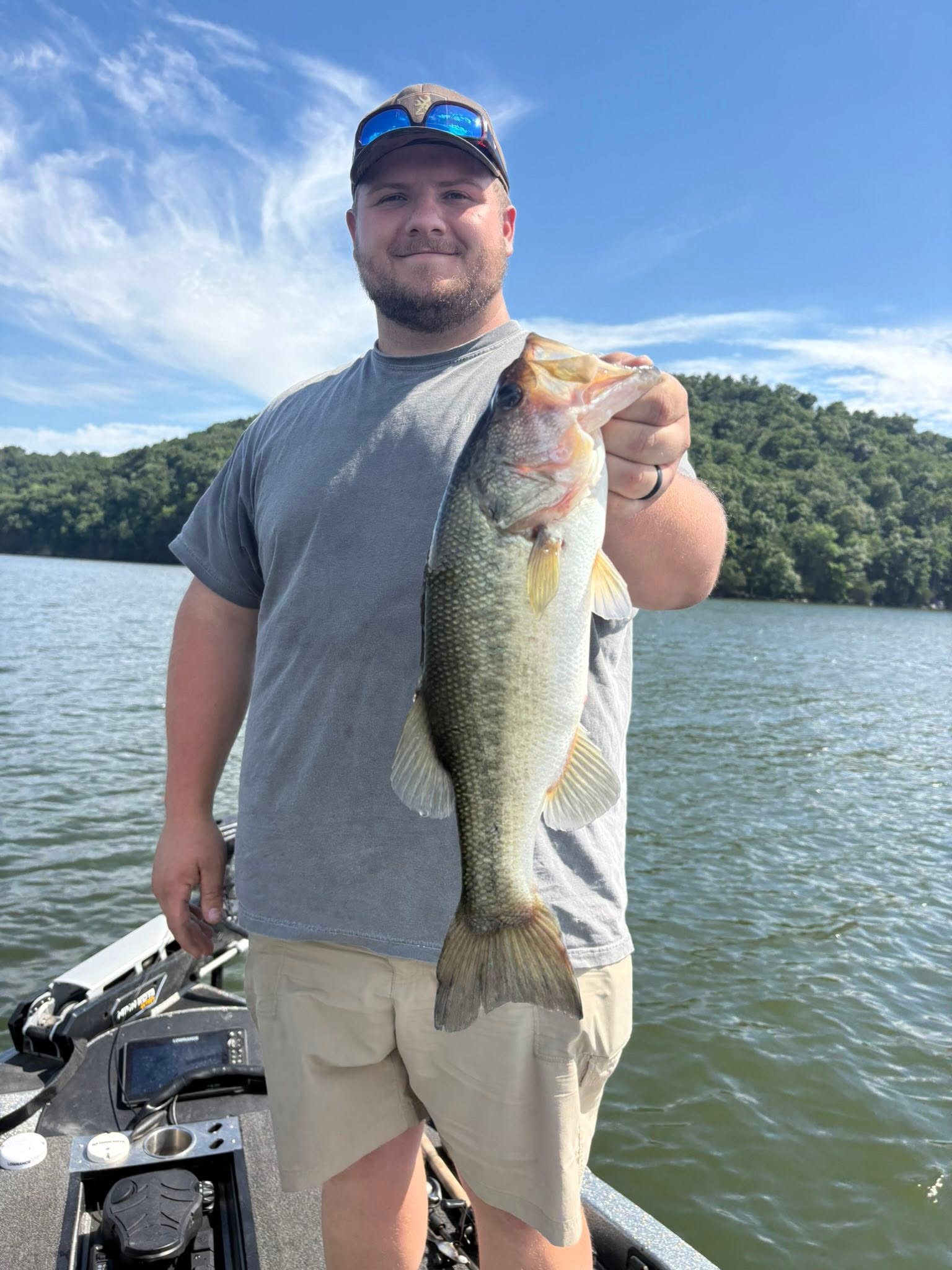 Angler holding large bass fish on boat at Guntersville AL lake