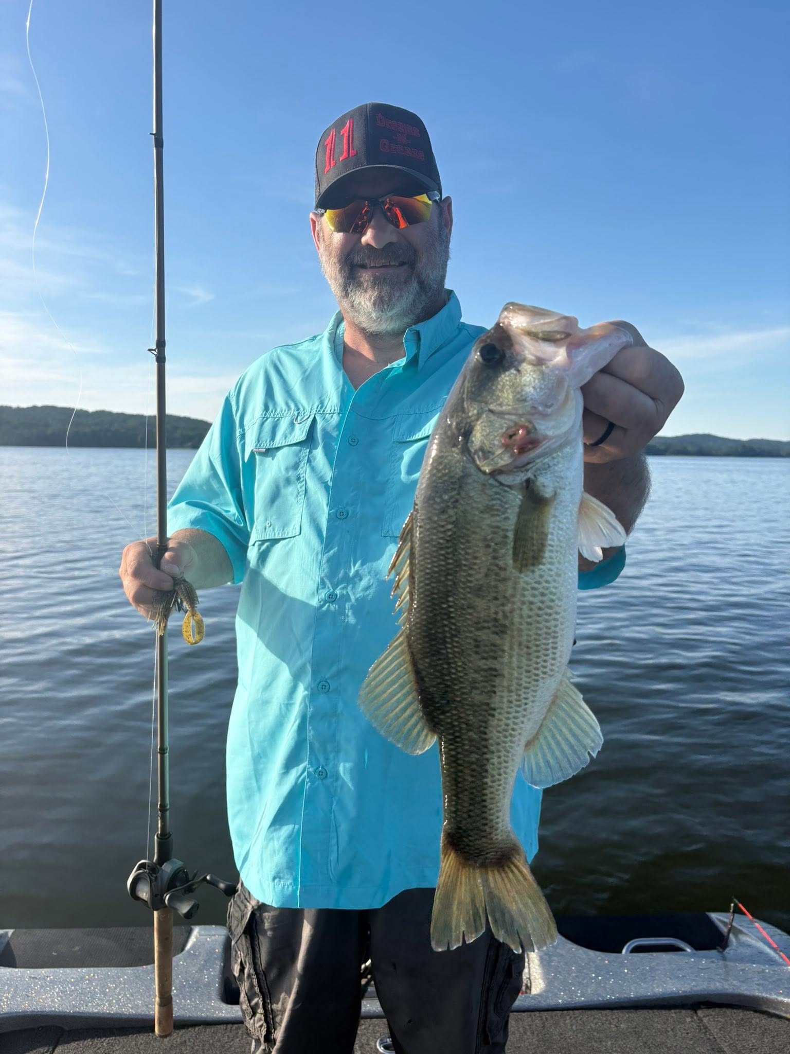 Angler holding large bass fish on boat in Guntersville AL lake