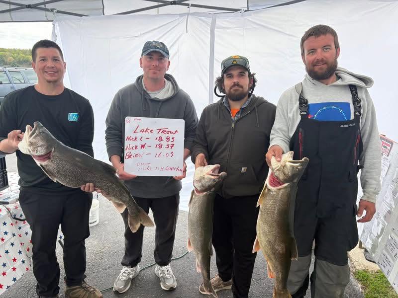 Four anglers displaying lake trout catch at fishing tournament weigh-in in Ogdensburg NY