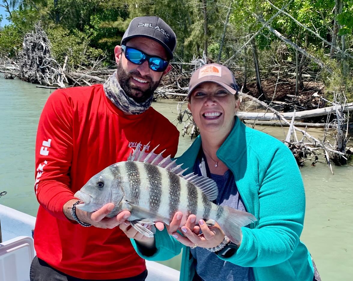 A fisherman holding a sheepshead fish while fishing in FL