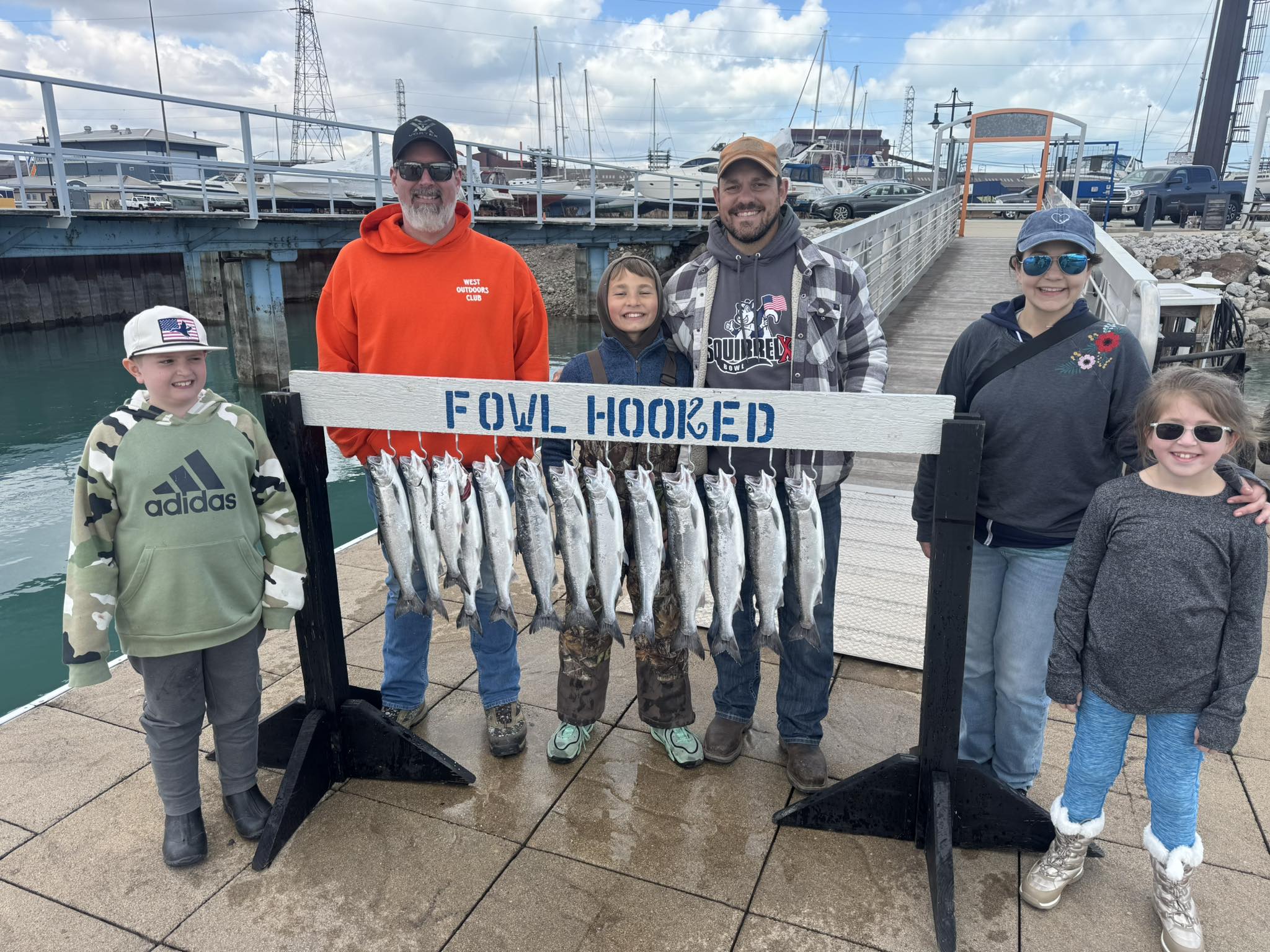 Successful coho salmon fishing trip display at East Chicago IN marina with multiple fish hanging from rack