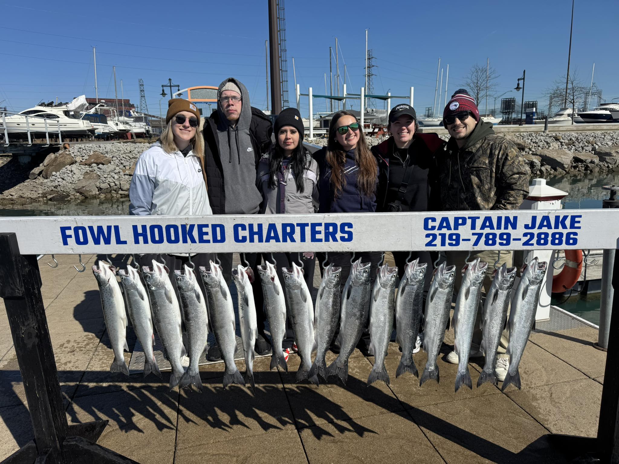 Successful salmon fishing charter in East Chicago IN with multiple coho and chinook salmon displayed on cleaning station