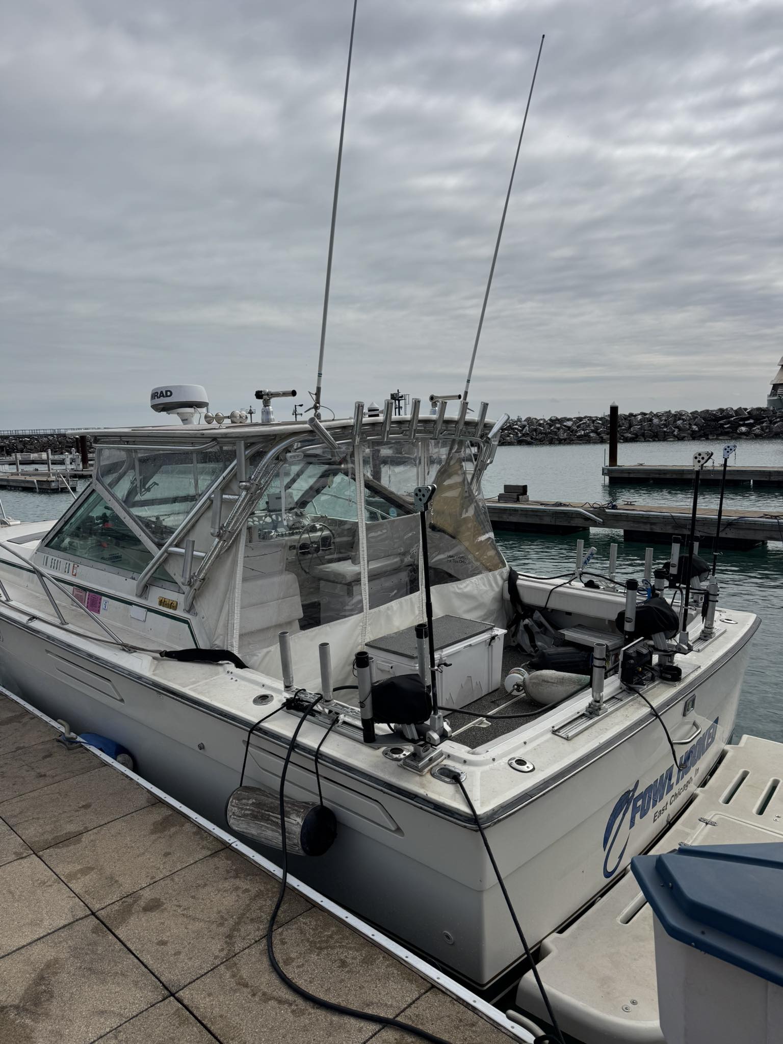 White fishing boat with glass cabin and fishing rods docked at East Chicago IN marina