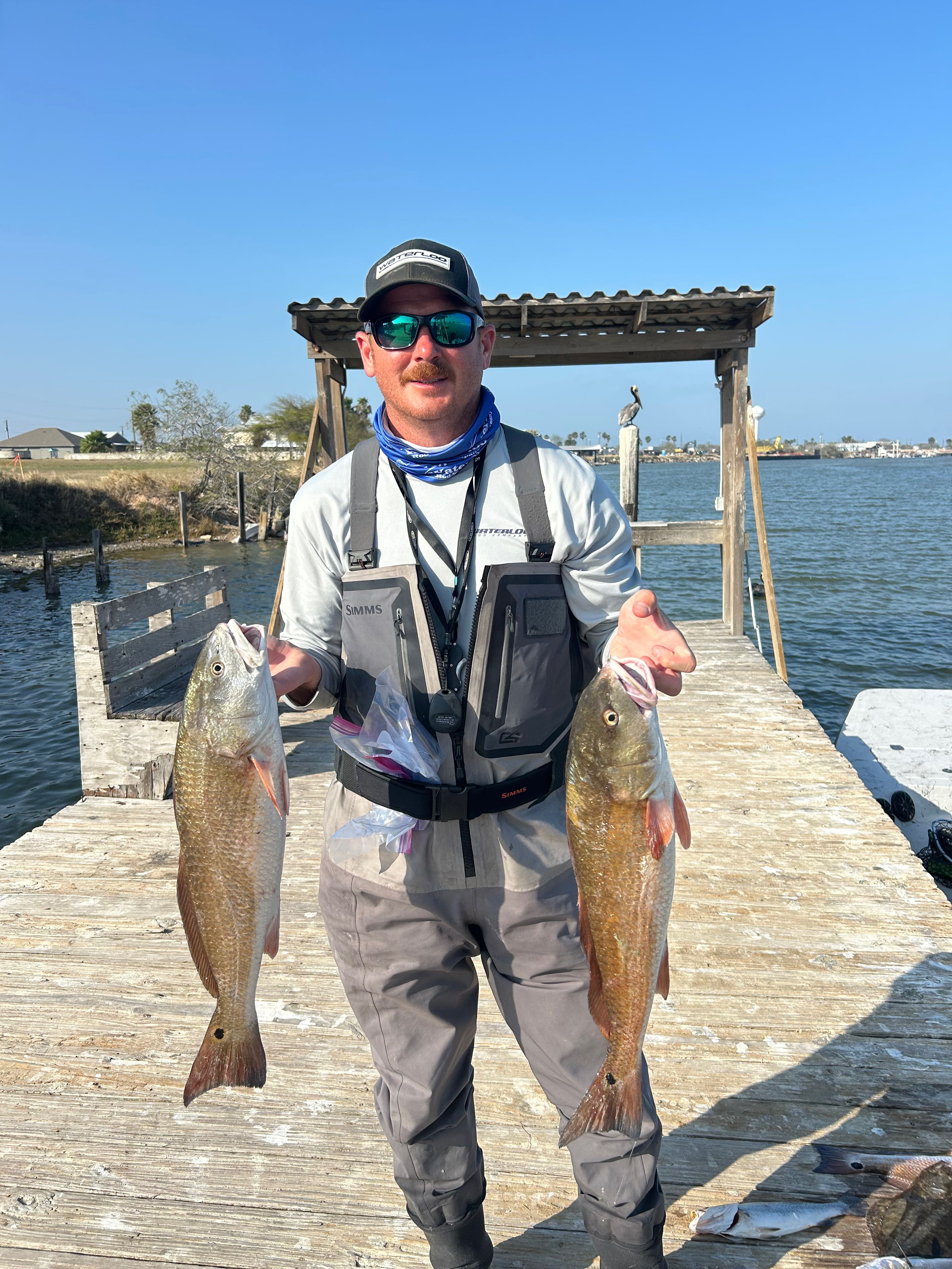 Two redfish caught fishing in Rockport TX displayed on wooden dock