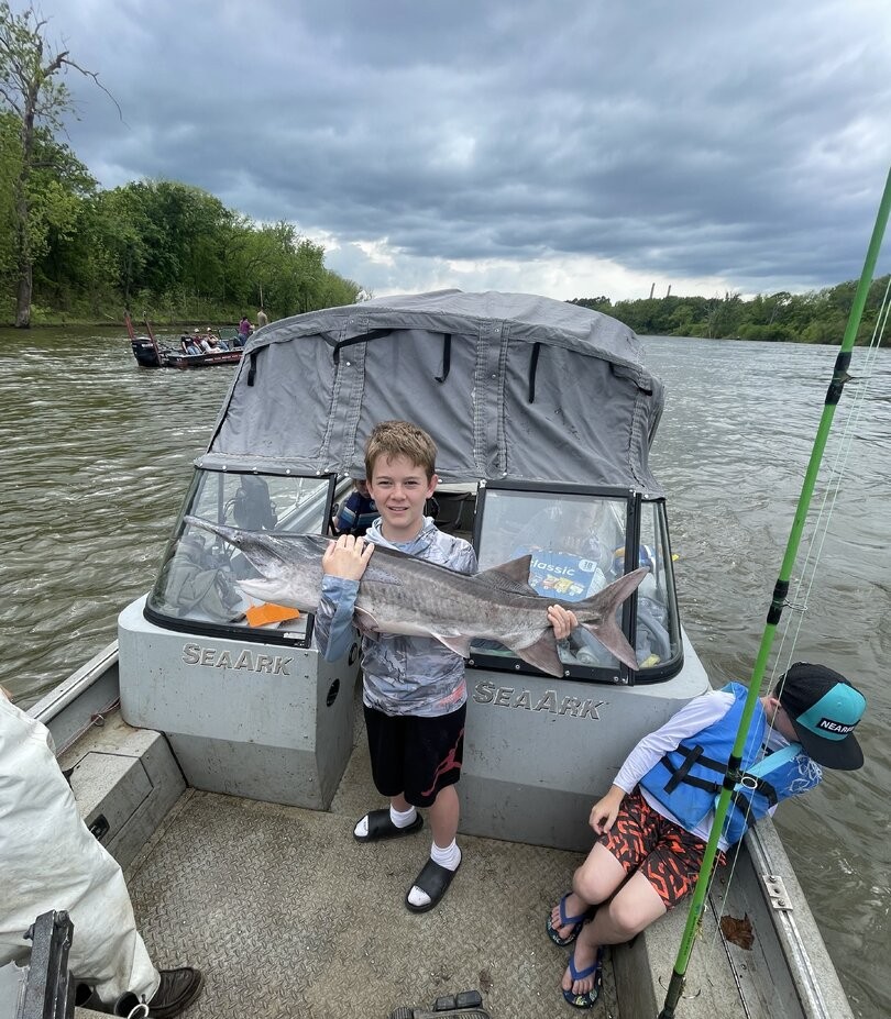 Young angler holding caught fish on fishing boat in Sand Springs OK