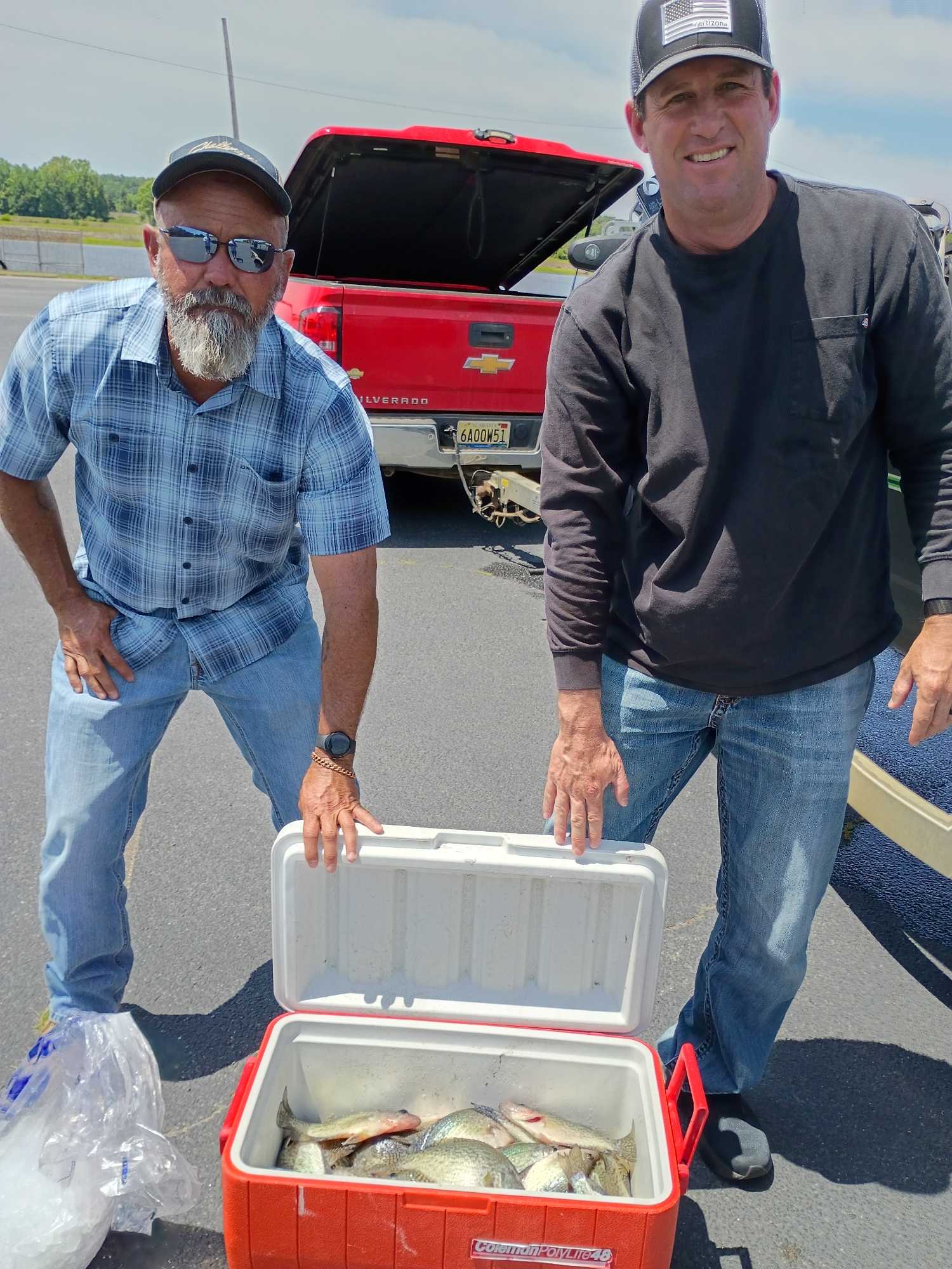 Two anglers displaying their catch in a cooler after a successful fishing trip in Eufaula AL