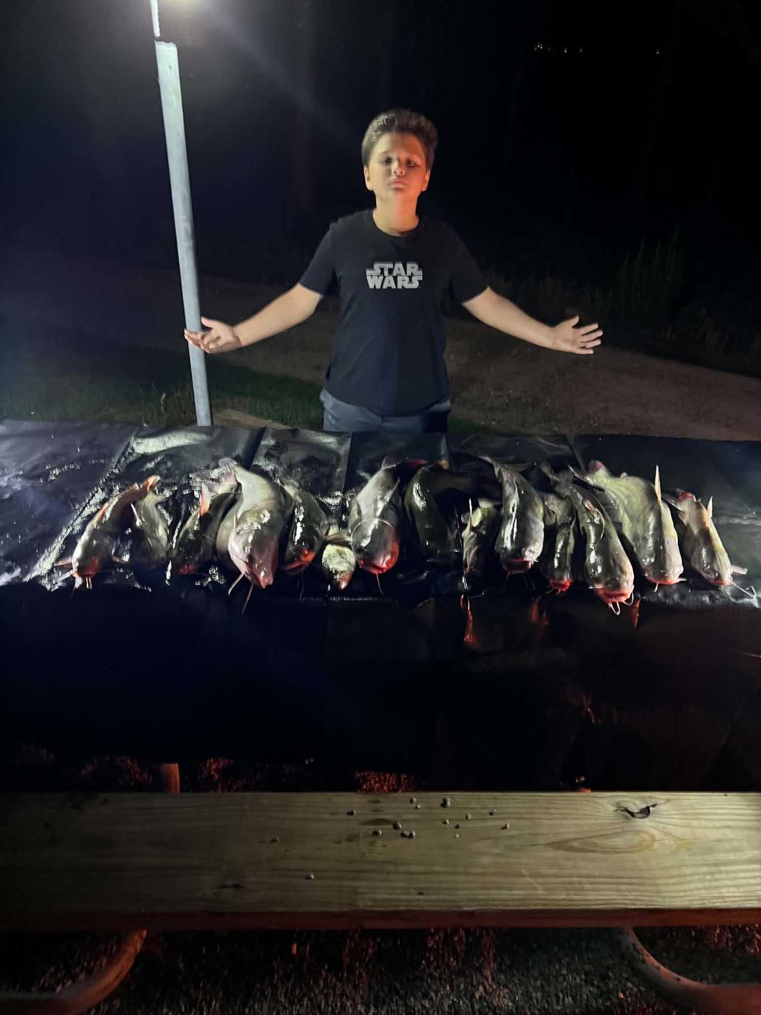 Successful night fishing catch displayed on wooden dock in Eufaula AL with multiple fish arranged in rows