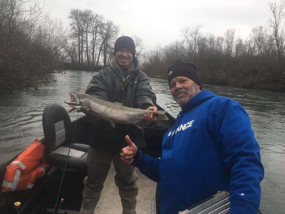 Two people fishing in Oregon with a single, large fish
