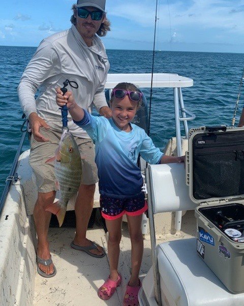 Two anglers proudly display their catch in the sunshine of Florida