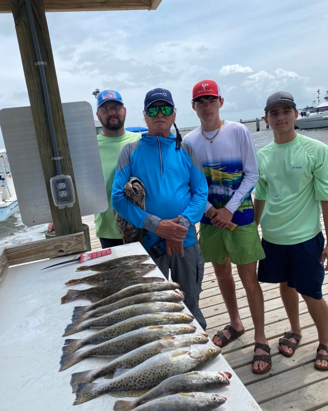 Four people fishing for a spotted weakfish on Dauphin Island