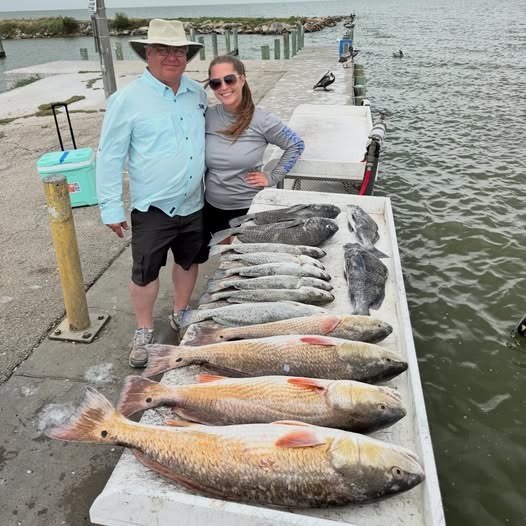 Successful redfish fishing trip in League City TX showing multiple caught fish displayed on dock