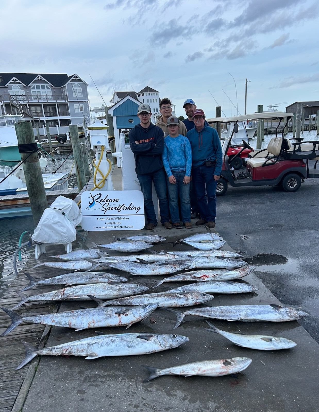 Successful fishing charter in Hatteras NC with King Mackerel and Bluefish catch displayed on marina dock
