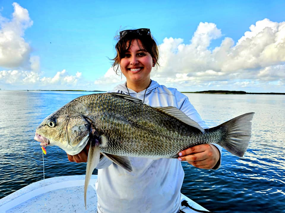 Angler holding a massive black drum fish caught in Port Isabel