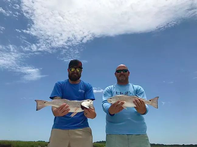 Two anglers holding their impressive catch in South Carolina