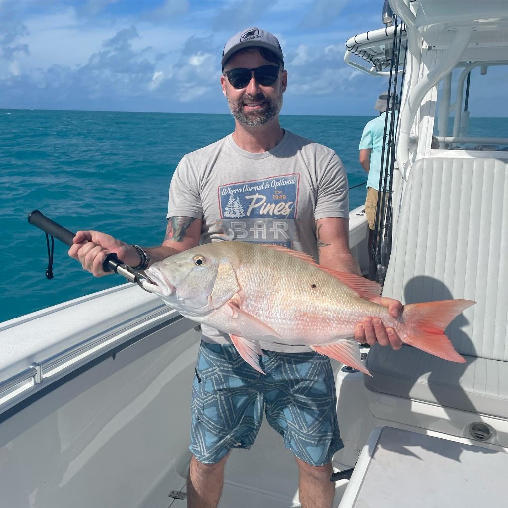 A fisherman holding a large mutton snapper in Key West, Florida.