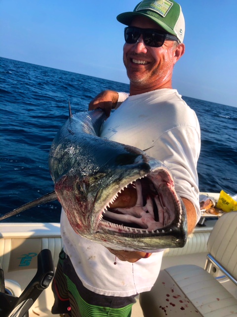 Large barracuda with open mouth showing sharp teeth caught on fishing boat in New Smyrna Beach FL