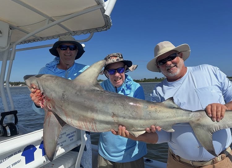 Shark fishing charter boat with anglers battling sharks off New Smyrna Beach Florida coast