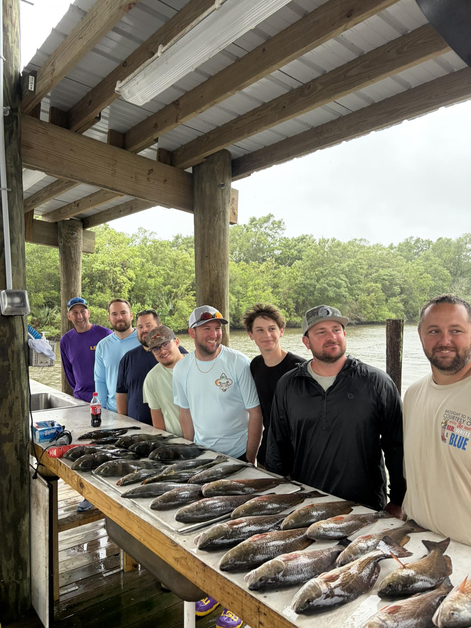 Fishing group displaying large catch of fish on cleaning station table in Hopedale LA