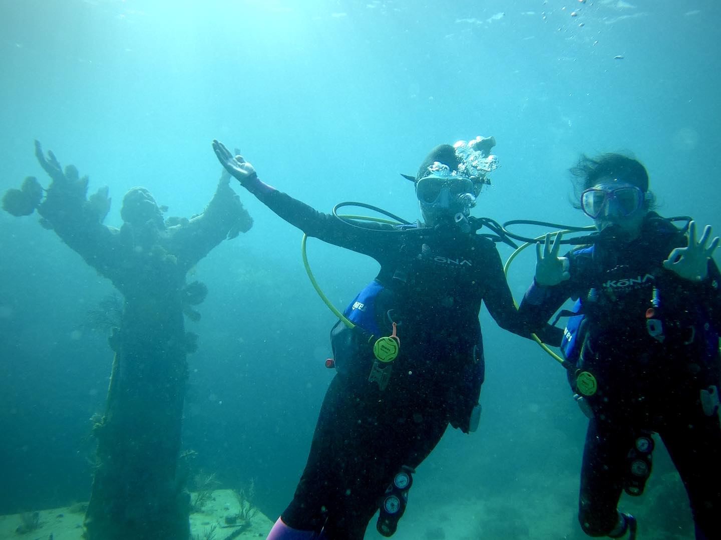 Scuba divers underwater making hand signals during a dive