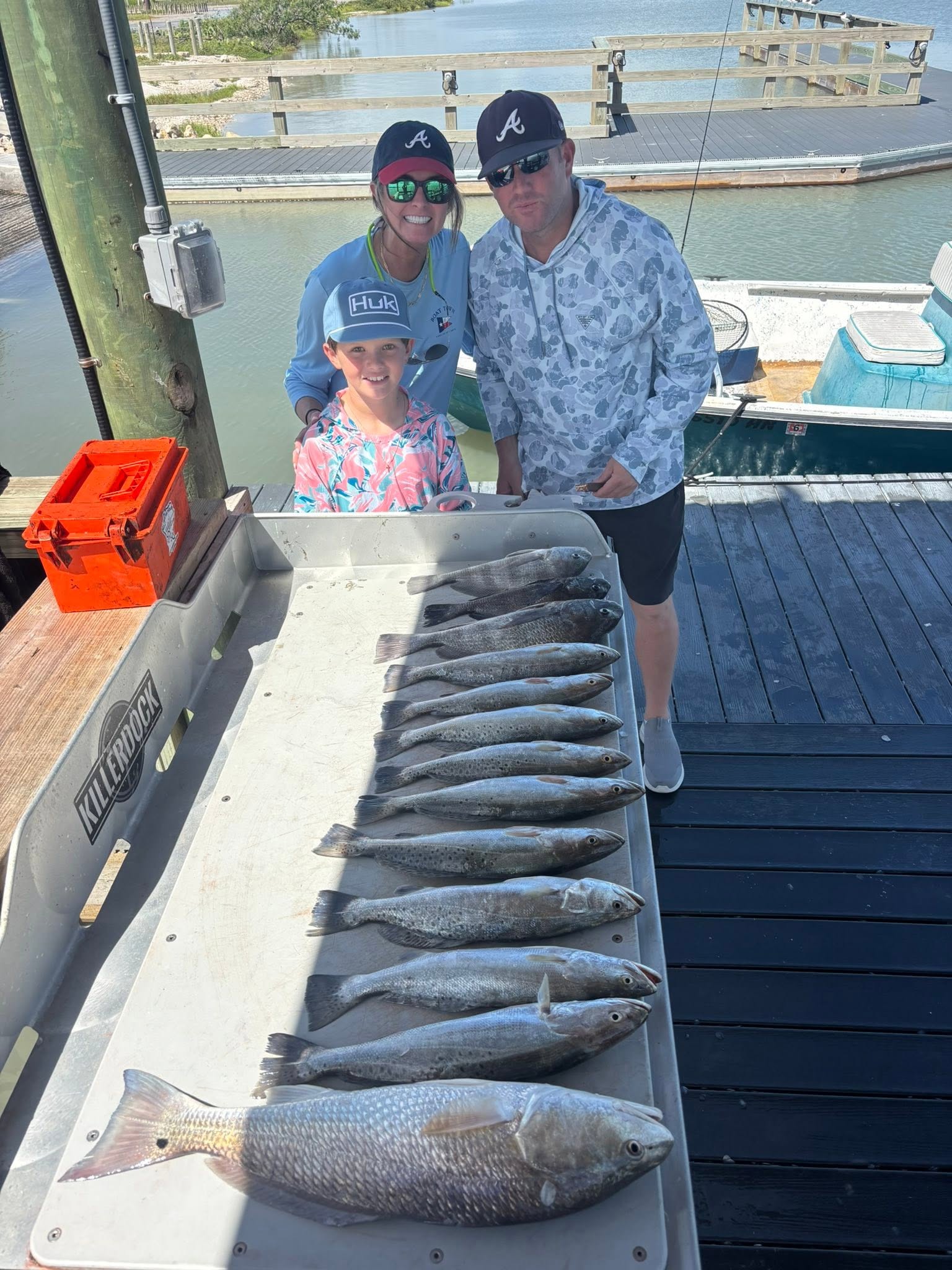 Successful fishing trip in Corpus Christi TX displaying redfish, speckled trout, and black drum catch on boat