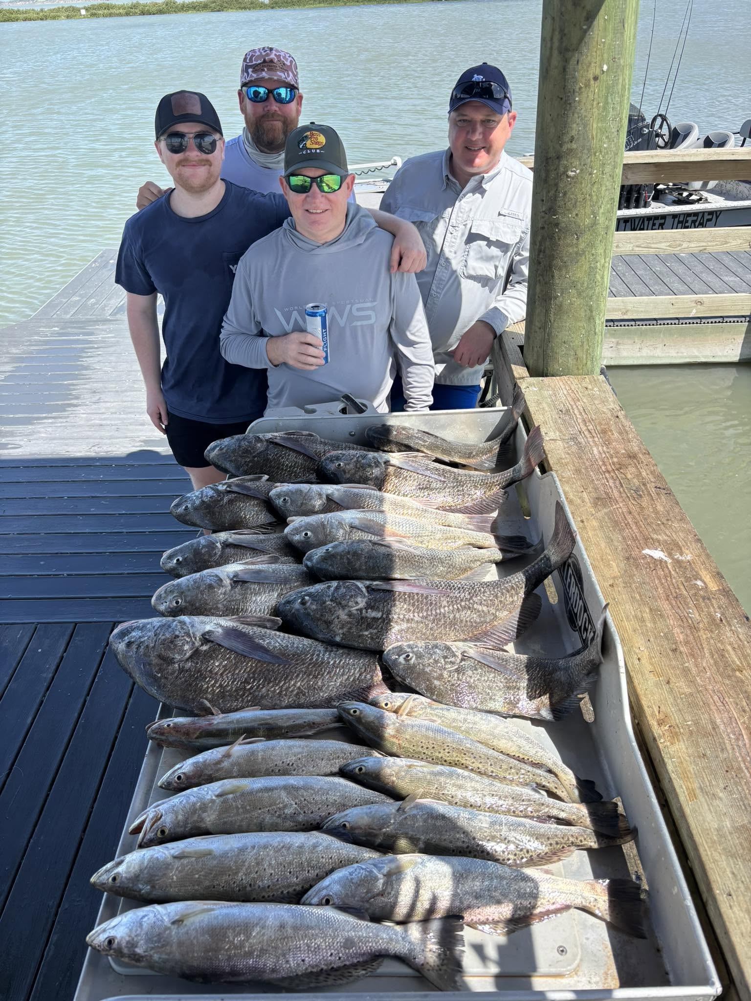 Large fishing catch of speckled trout and black drum displayed on dock in Corpus Christi TX