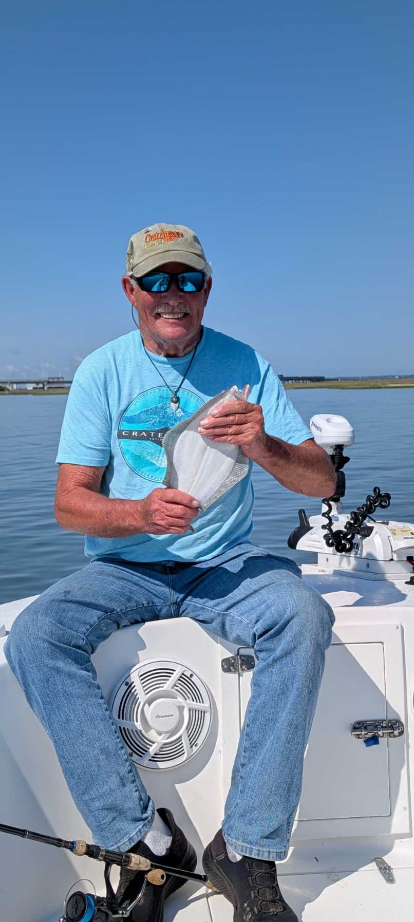 Fishing guide on boat displaying catch in Chincoteague VA waters
