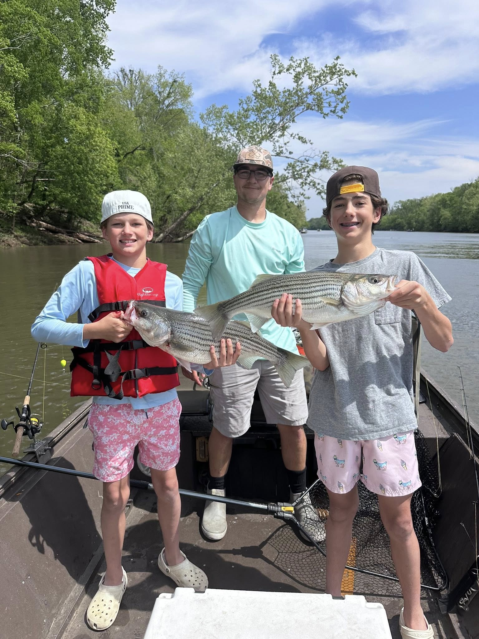 Two striped bass caught fishing in Weldon NC with fishing boat on river