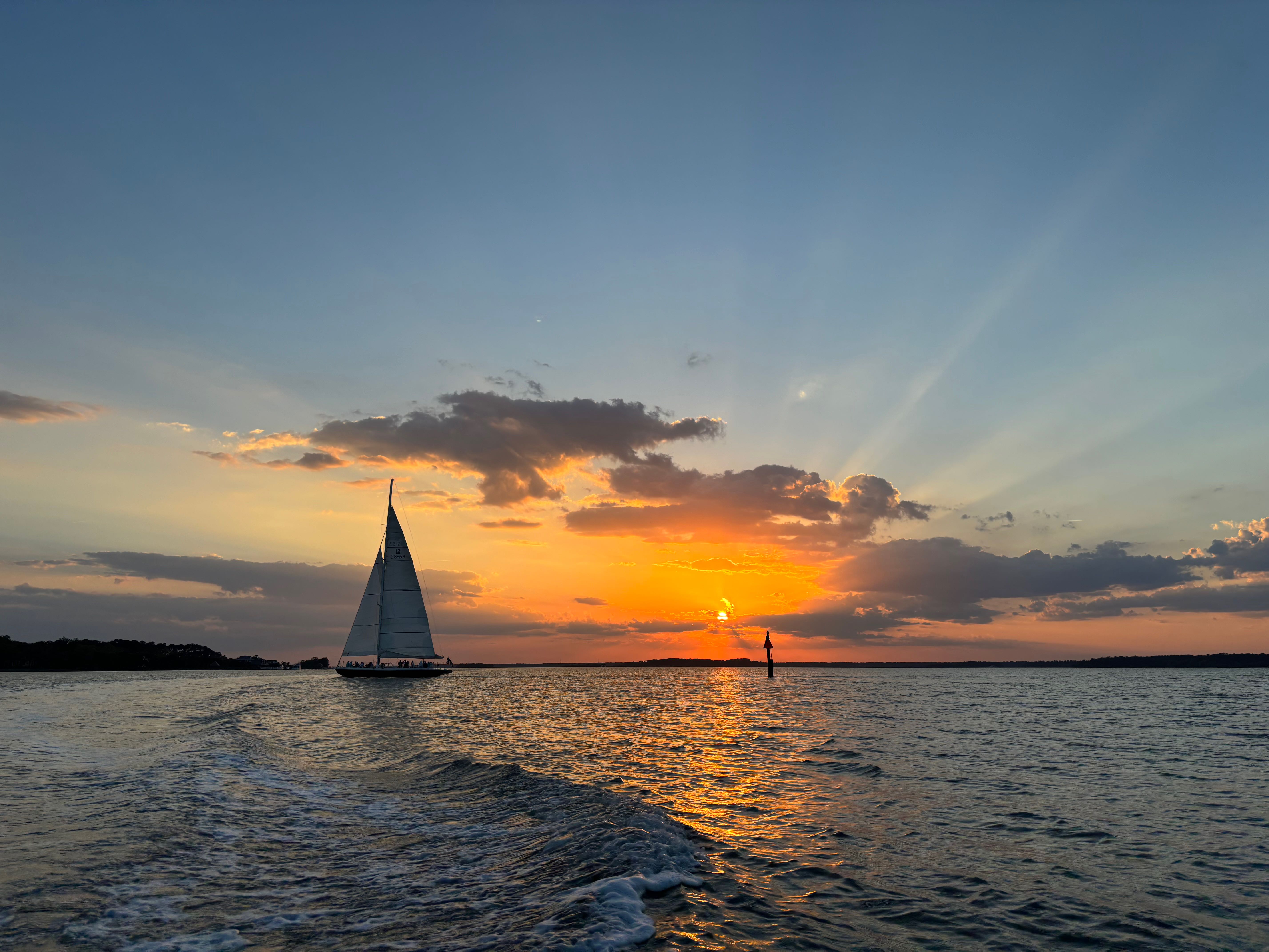 Sailboat on calm water during golden sunset in Bluffton SC
