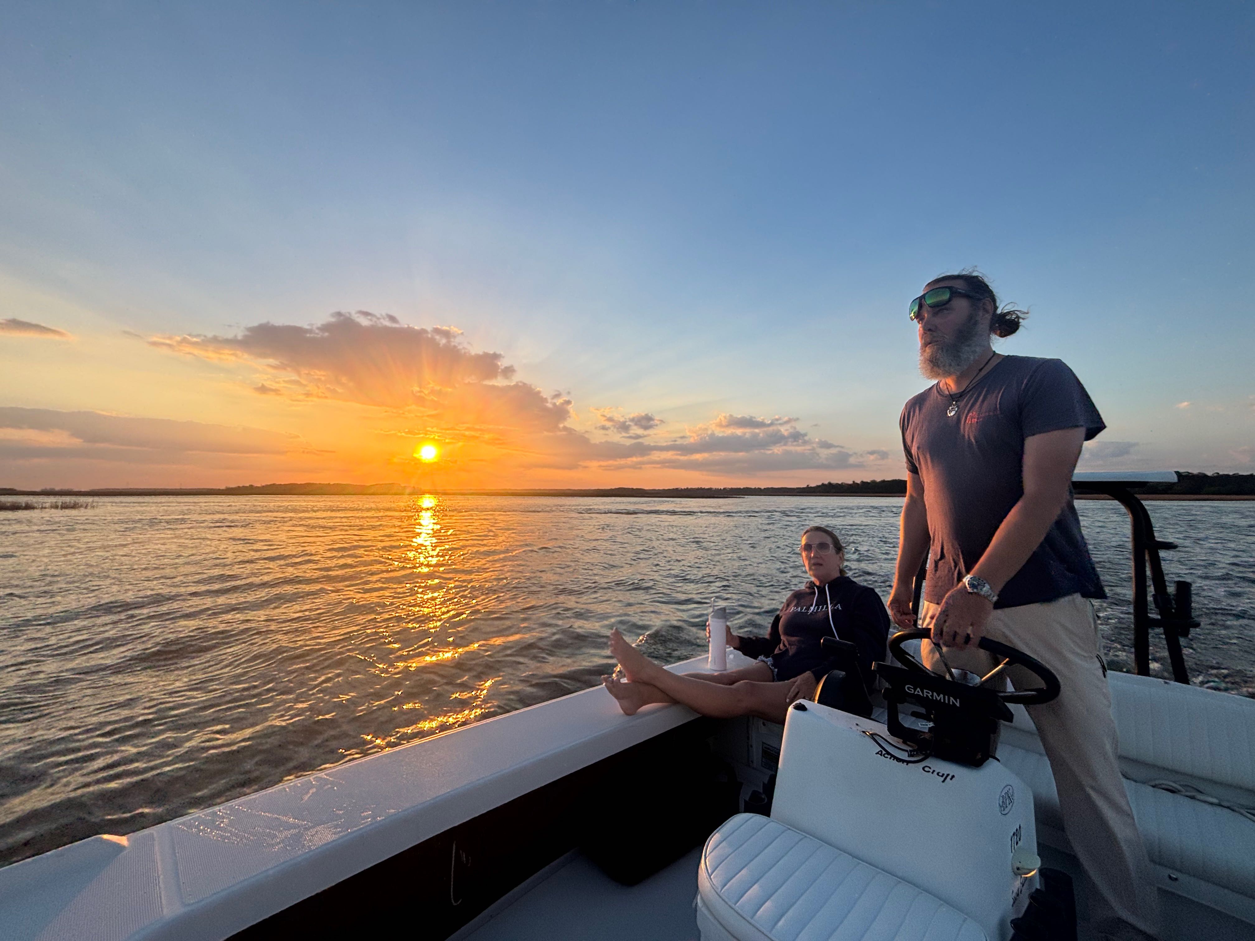 Sunset fishing tour on calm waters near Bluffton SC with boat navigating during golden hour