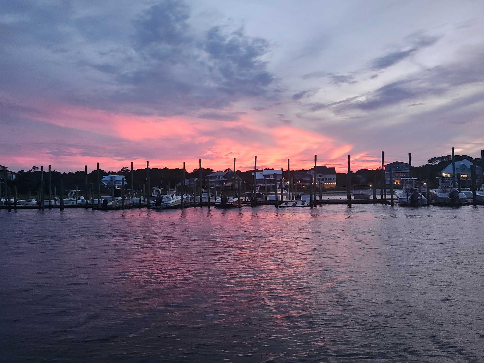 Sunset view over Carolina Beach NC marina with boats docked at pier
