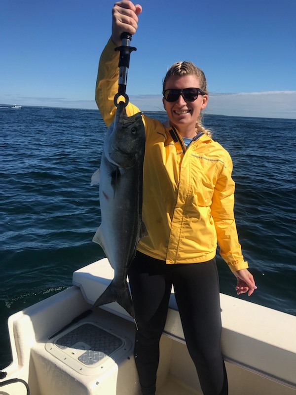 A person fishing for a bluefish in New London