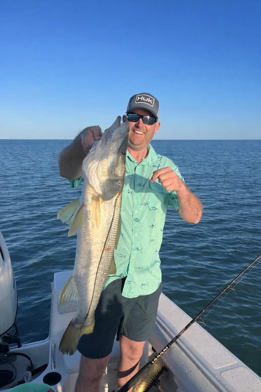 Angler holding large snook catch on fishing boat in Madeira Beach Florida waters