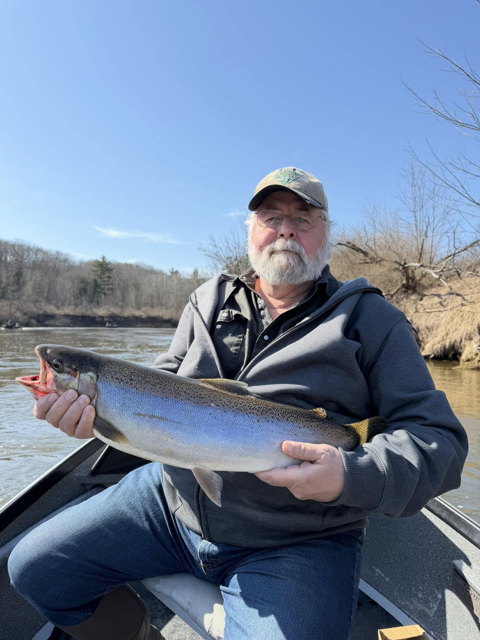 Angler holding freshly caught fish on boat in Brethren MI