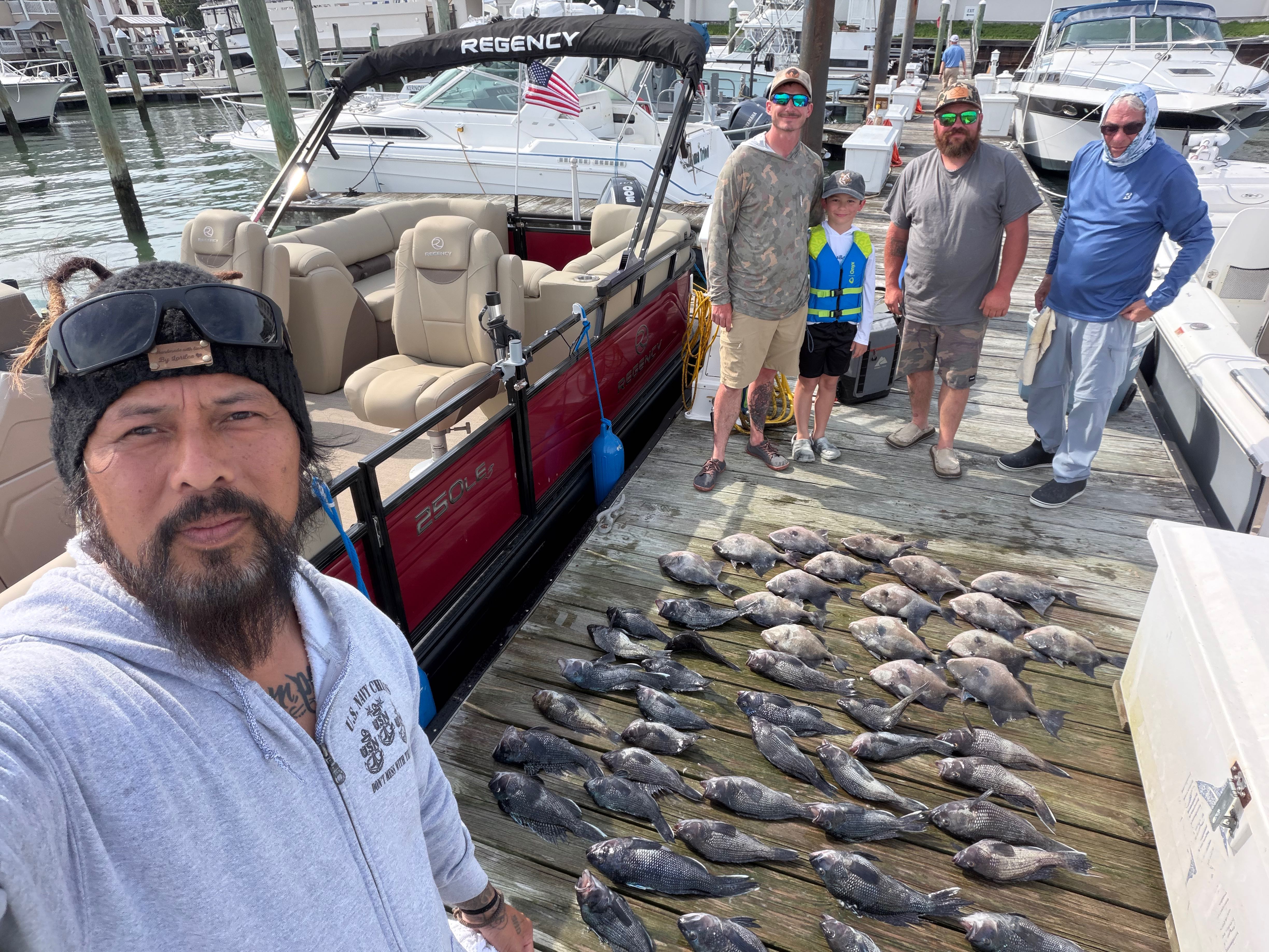 Large catch of fish displayed on marina dock in Virginia Beach VA after successful fishing charter